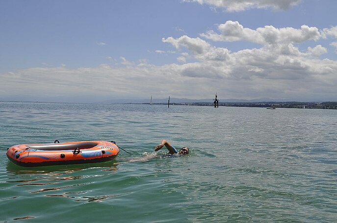 Verena Röck schwimmt mit Schlauchboot über den Bodensee